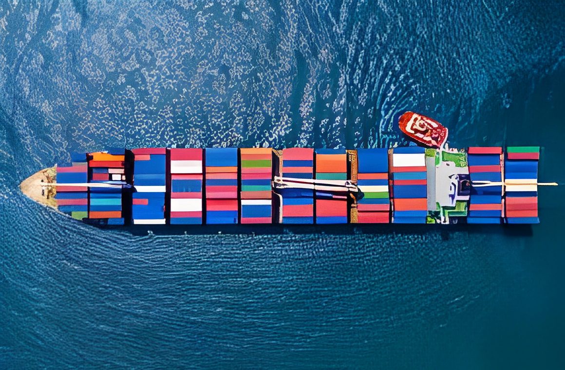 Aerial view of a container ship with colorful cargo containers, traveling through blue water.