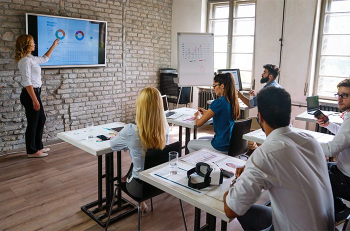 People attending a presentation in a modern office setting.