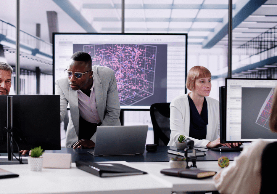 Team of professionals collaborating in a modern office with large digital screen.